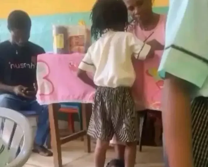 A teacher interacting with pupils in a classroom, highlighting the importance of child safety and positive discipline in schools.